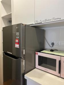 史里肯邦安TheSevenBahrin Homestay的厨房配有冰箱和微波炉。