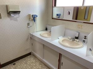 松本末广酒店的浴室设有2个水槽和镜子