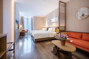 龙岗丽呈朗誉酒店（深圳龙岗大运中心城店）的酒店客房,配有床和沙发
