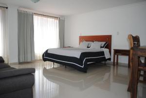 潘普洛纳COLOMBIA-Hotel Hontibon的一间卧室配有一张带黑白毯子的床