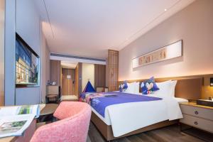 龙岗丽呈朗誉酒店（深圳龙岗大运中心城店）的酒店客房设有一张大床和一张书桌。