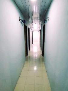 名古屋Homestay 81 Batu Batam的长长的走廊,天花板上设有长长的走廊,灯亮