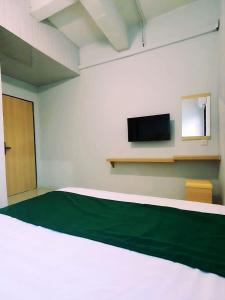 名古屋Homestay 81 Batu Batam的客房设有一张床和一台平面电视。