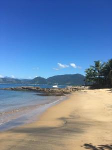 安格拉杜斯雷斯Angra dos Reis - Casa pé na areia na Praia de Fora - Ponta Leste的棕榈树和海洋的沙滩