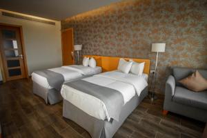 Al KhawḑSama Muscat Hotel的酒店客房,配有两张床和椅子