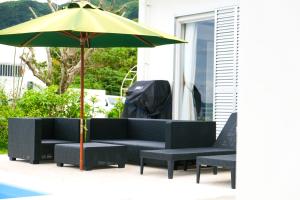 石垣岛Blue Ocean Resort的一个带沙发和遮阳伞的庭院
