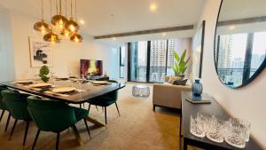 墨尔本Stylish Southbank apartment Plus Free Parking for 2 Cars的用餐室以及带桌椅的起居室。