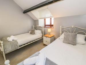 巴茅思Ceilwart Cottage的一间卧室设有两张床和窗户。