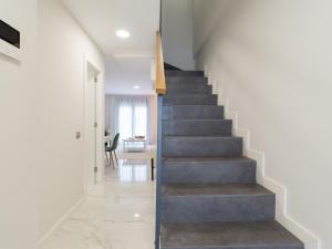 大加那利岛拉斯帕尔马斯Avatar Las Canteras的房屋内的楼梯,拥有白色的墙壁和混凝土地板