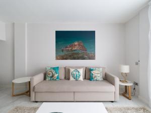 大加那利岛拉斯帕尔马斯Avatar Las Canteras的客厅配有沙发和墙上的绘画
