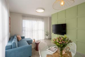 特拉维夫YalaRent Flora- Designed 1BR penthouse in Florentin的客厅配有蓝色的沙发和电视
