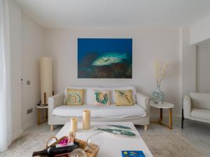 大加那利岛拉斯帕尔马斯Avatar Las Canteras的客厅配有白色沙发和鱼画