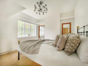 伦敦Cheerful 3 bedroom luxury house的卧室配有一张带吊灯的大型白色床。