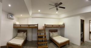 黎牙实比P&B Residences Legazpi的客房设有三张双层床和吊扇。