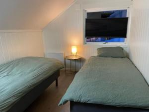 灵塞德House with garage in central Lyngen的一间卧室设有两张单人床和一个窗户。