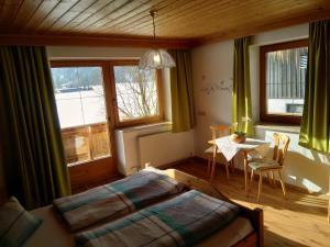 阿亨湖Tischlerhof的卧室配有床、桌子和窗户。