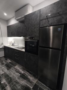 哈尔基斯Chalkida Hilltop Apartments的厨房配有不锈钢冰箱和水槽