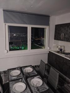 哈尔基斯Chalkida Hilltop Apartments的一间带桌子和窗户的用餐室