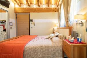 奥斯塔仙果住宿加早餐旅馆 的一间卧室配有一张带橙色毯子的大床