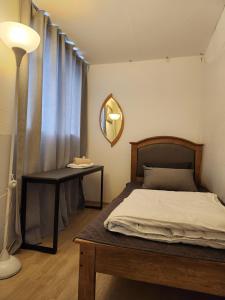 江陵市Aark旅舍的一间卧室配有一张床、一张桌子和一面镜子