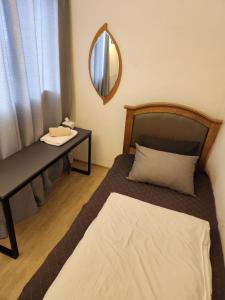 江陵市Aark旅舍的一间卧室配有一张床、一个梳妆台和镜子