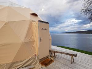 GlåmosRøros Arctic Dome的湖前带长凳的大帐篷