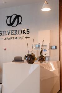 PrilimanskoyeSilveroks Apartment的标牌前有两瓶花的柜台
