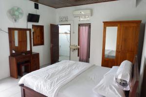 AbeansemalKarauci Homestay的卧室配有白色的床和镜子