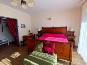 洛夫兰Apartments Orange Lovran的一间卧室配有一张带粉红色床罩的木床