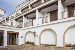 阿尔加尔Hotel Tugasa Villa de Algar的享有白色建筑和拱门的外部景色
