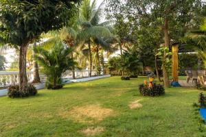 AgacaimBrit's Palace Goa的棕榈树庭院和围栏