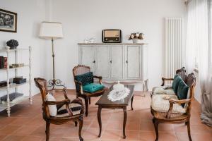 科尔恰诺Locanda Mescoglia的客厅配有椅子和橱柜上的电视