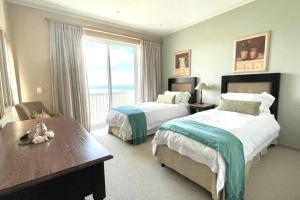 DʼAlmeidaLuxury at Pinnacle Point - 3 Bedroom Villa的酒店客房设有两张床和大窗户。