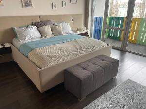 绿山城3bedroom Smarthome apartment, close to city center的卧室内的一张大床和一张带搁脚凳的睡床