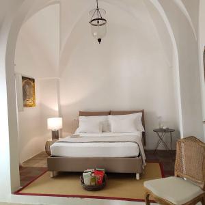 马蒂诺Agata Salento Luxury Home的一间卧室配有一张床和一把椅子