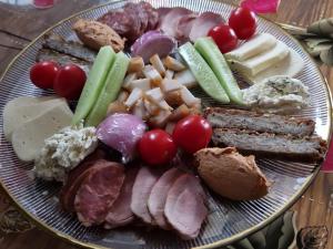 布泽乌河畔恩托尔苏拉Complex Dealu' Frumos的桌上一盘带肉和蔬菜的食物