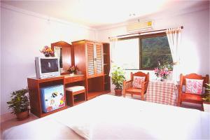 奥南海滩J大厦酒店的一间卧室配有一张床,并在一间客房内配有电视。