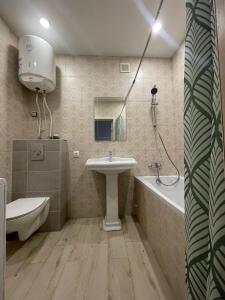 布恰Подобово ЖК Центральний вул.Нове Шосе, 8А的浴室配有盥洗盆和浴缸。