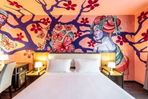 卡斯泰尔达扎诺Muraless Art Hotel的卧室配有一张大床,墙上挂有绘画作品