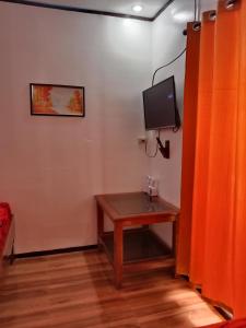 爱妮岛KIMURA PENSION的一间设有桌子的房间和墙上的电视