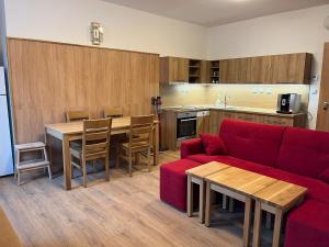 NýdekApartmány Nýdečanka的一间带红色沙发的客厅和一间厨房