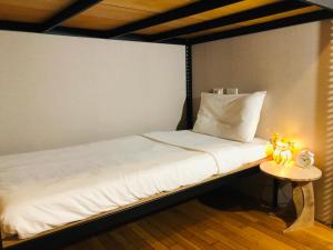 台北Hostel of Rising Sun 昇行旅的一张位于带边桌的房间内的床铺