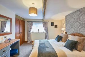 布拉夫Cosy Cumbrian cottage for your country escape的一间卧室配有一张床、一张书桌和一个窗户。