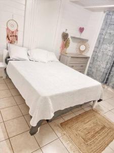 勒拉芒坦villa La Mérédith的一间卧室配有一张带白色床单的大床