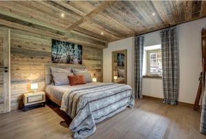 圣热尔韦莱班Chalet de L'Ours Blanc的一间卧室设有木墙和一张床