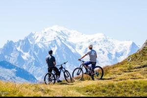 圣热尔韦莱班Chalet de L'Ours Blanc的两个骑着自行车的人,骑在雪覆盖的山丘上