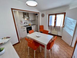 坎波内莱尔巴Appartamenti Via Roma 41的厨房以及带白色桌椅的用餐室。