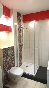 达洛科Apartament Jantar 3B w Darłówku的浴室设有卫生间和带红色橱柜的淋浴。