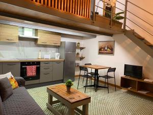 艾因西莱姆Ta Serafina studio apartment with loft的厨房以及带沙发和桌子的客厅。