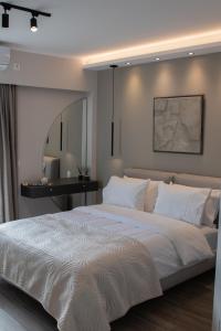 迈索隆吉翁Langi Apartments的卧室配有一张大白色的床和书桌